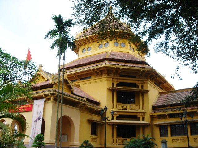 The facade of the National Museum of Vietnamese History in Hà Nội, a curved tile roof, palm trees in front.