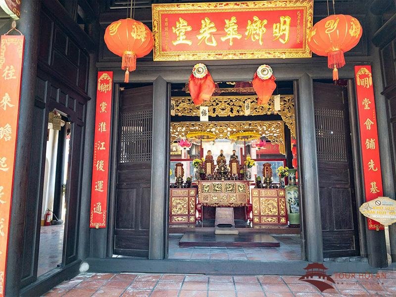 Nhìn qua cửa gian giữa vào chính điện: hoành phi sơn son thếp vàng khắc bốn chữ Hán treo phía trên, hai câu đối đỏ dọc theo khung cửa, đèn lồng đỏ hai bên, khám thờ chạm vàng sâu bên trong với ba pho tượng nhỏ ngồi trên bệ.