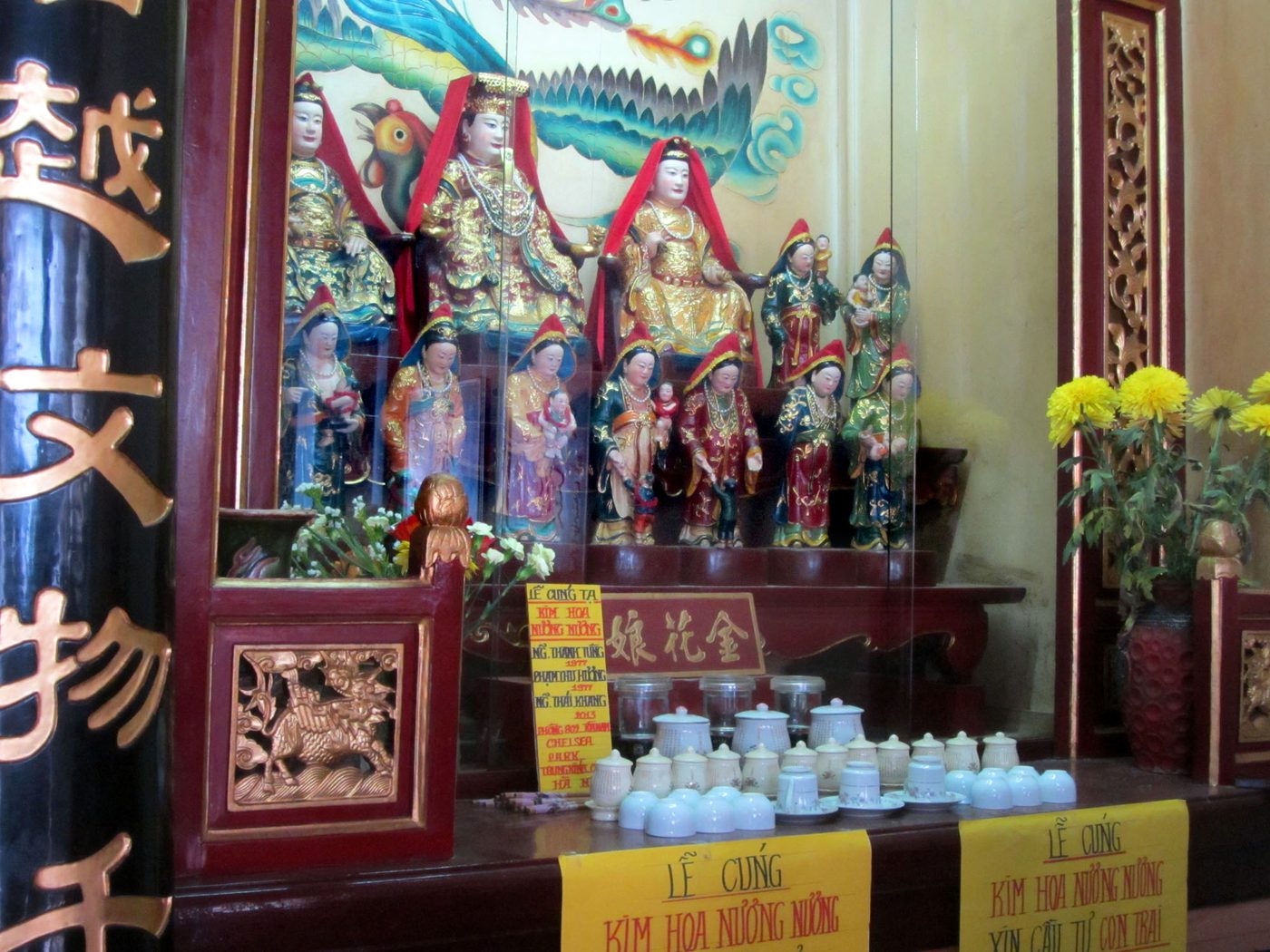 Khám thờ với các pho tượng nữ thần ngồi sơn son thếp vàng ở tầng trên, hàng tượng thị nữ đứng phía dưới, vài tượng bồng trẻ nhỏ trong tay, hoa cúc vàng và chén nước cúng bày phía trước, biển hiệu ở chân khám ghi tên Kim Hoa Nương Nương bằng cả chữ Việt và chữ Hán.