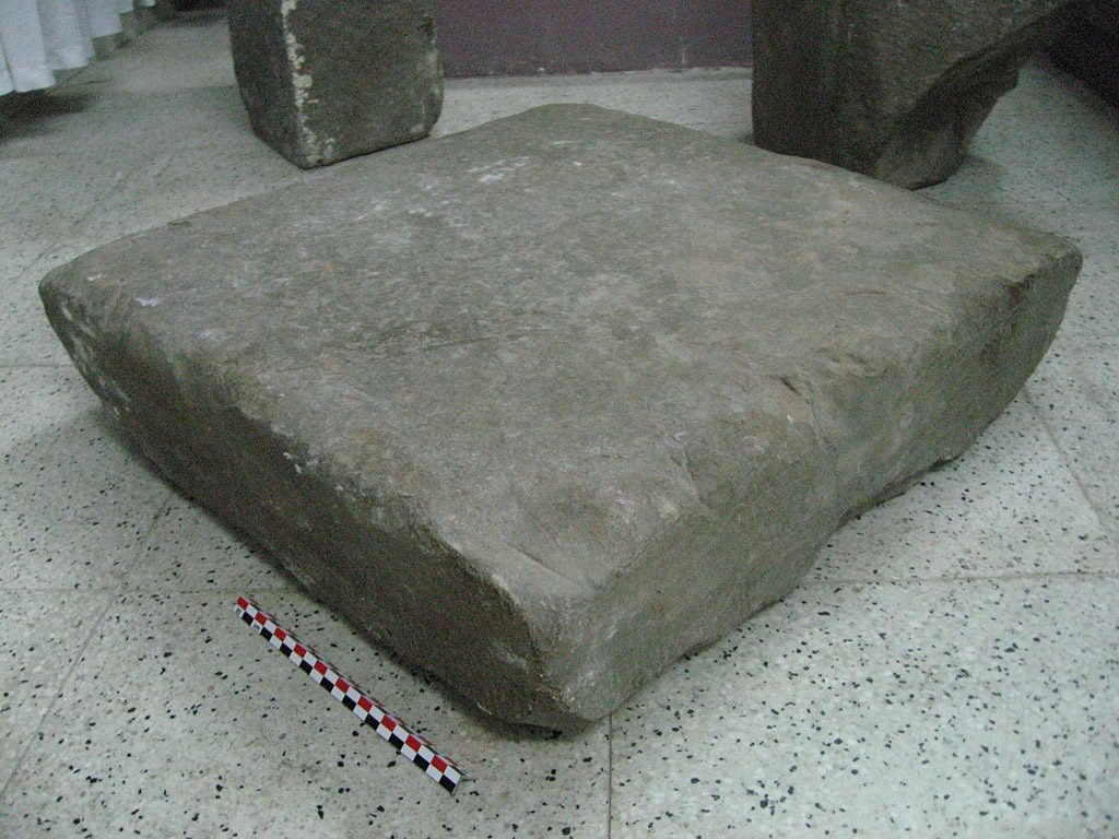 A square, low stone pedestal, inscription C.173 from Trà Kiệu, photographed in a museum storeroom in Hà Nội.